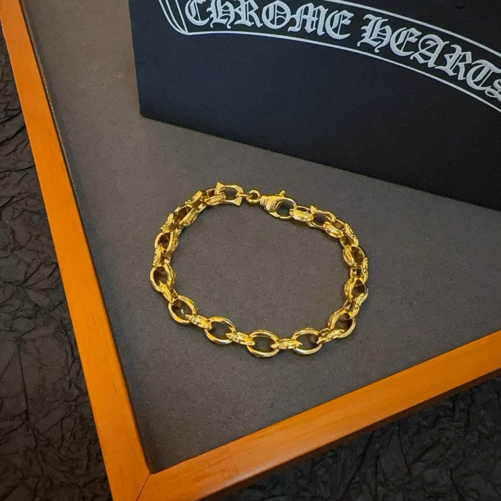 Gold oval-link chain bracelet on a gray gift box