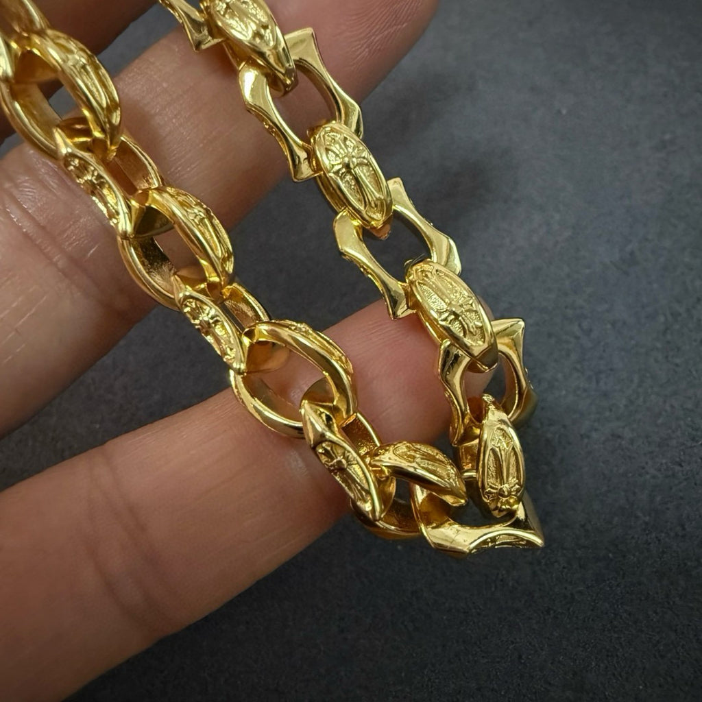 Close-up of a gold chain bracelet with detailed oval and bar links