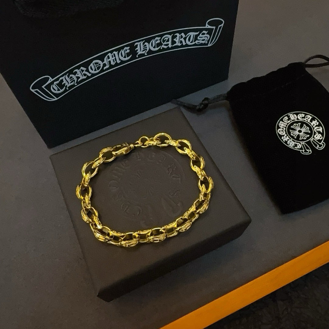 Gold chain bracelet with repeating links on a gray display card