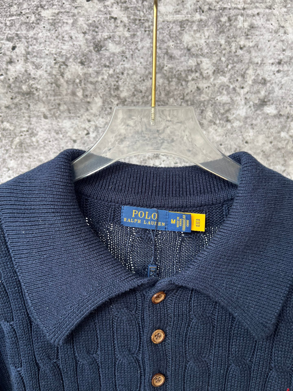 Navy ribbed polo sweater neckline with button placket and brand tag