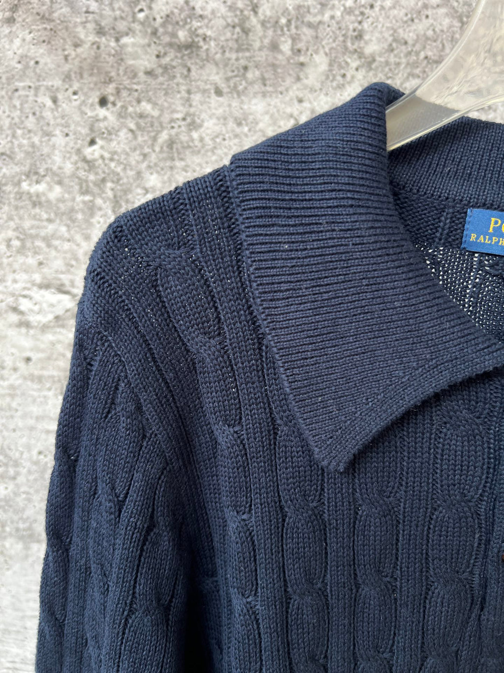 Navy knit polo sweater with ribbed cable-knit shoulder and collar