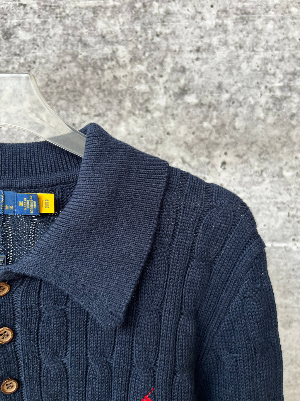 Navy knit polo sweater with ribbed collar and gold-toned button placket