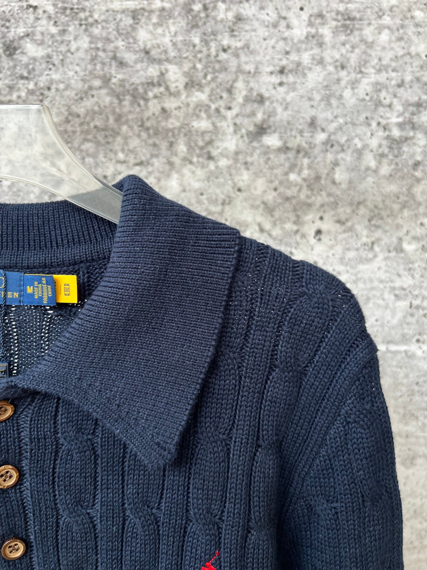 Navy knit polo sweater with ribbed collar and gold-toned button placket