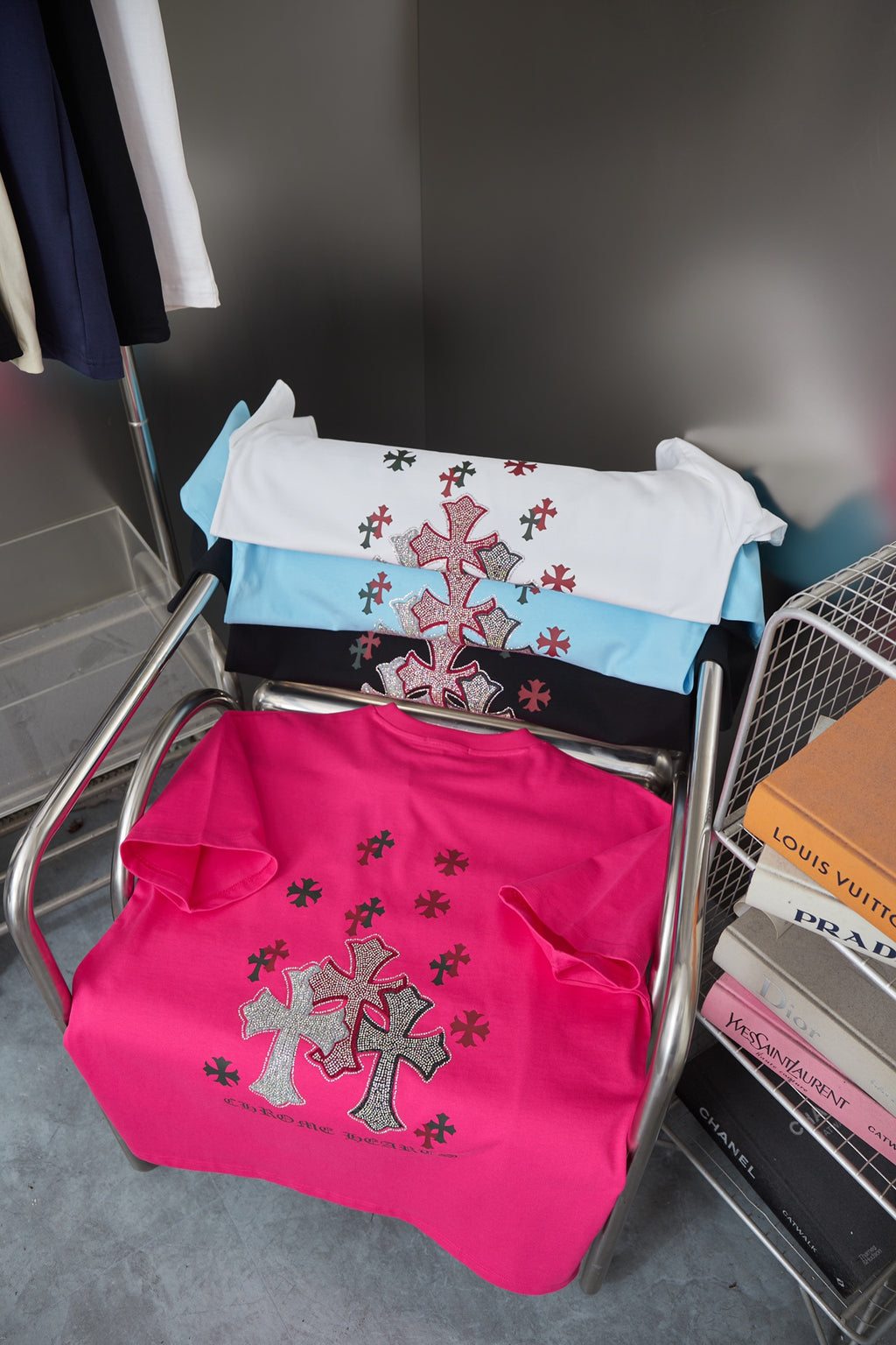 Stack of short-sleeve T-shirts, including pink with cross emblem