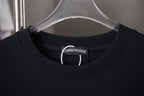 Black crewneck T-shirt with stitched neckline and brand tag on inner collar