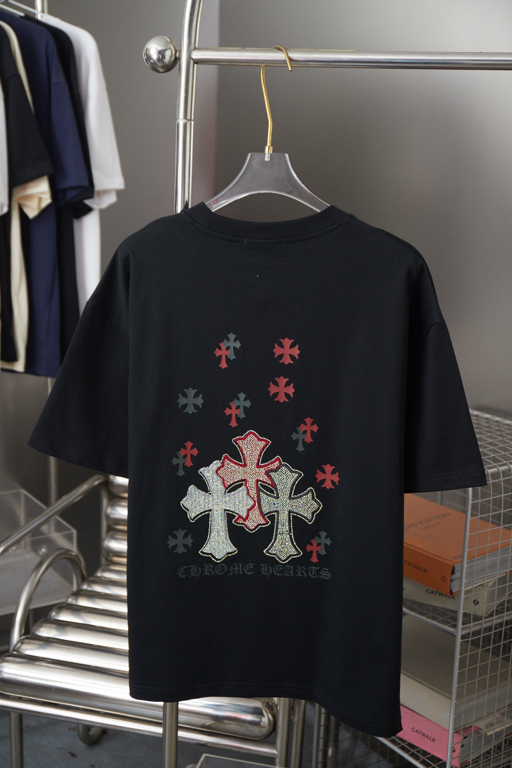 Black short-sleeve T-shirt with large cross and small red emblems on back
