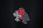 Black T-shirt detail of red cross applique with silver dot trim