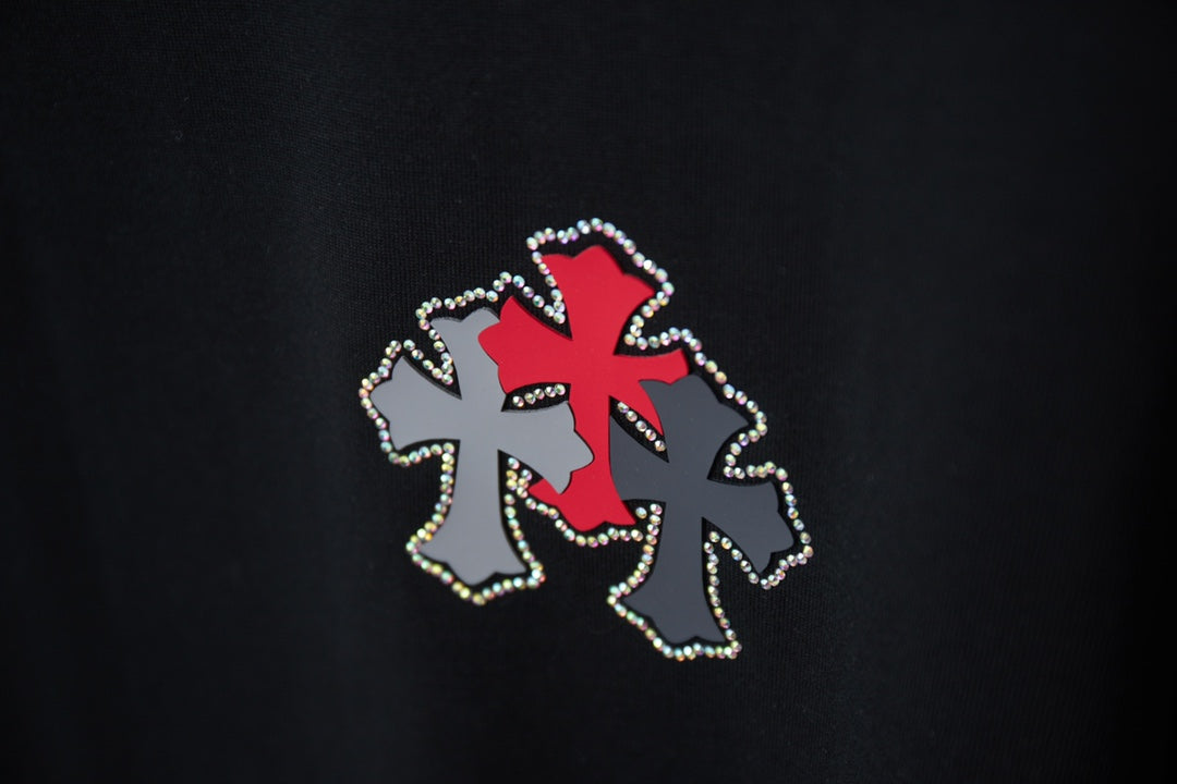 Black T-shirt detail of red cross applique with silver dot trim