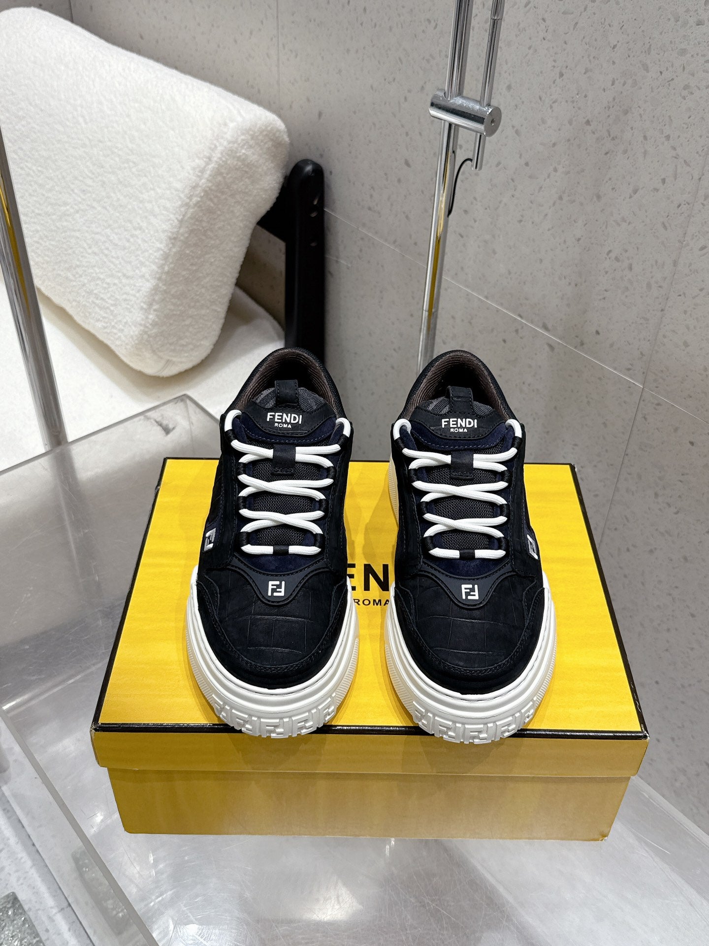 Black Fendi sneakers with white rubber sole, lace-up front, logo patches.