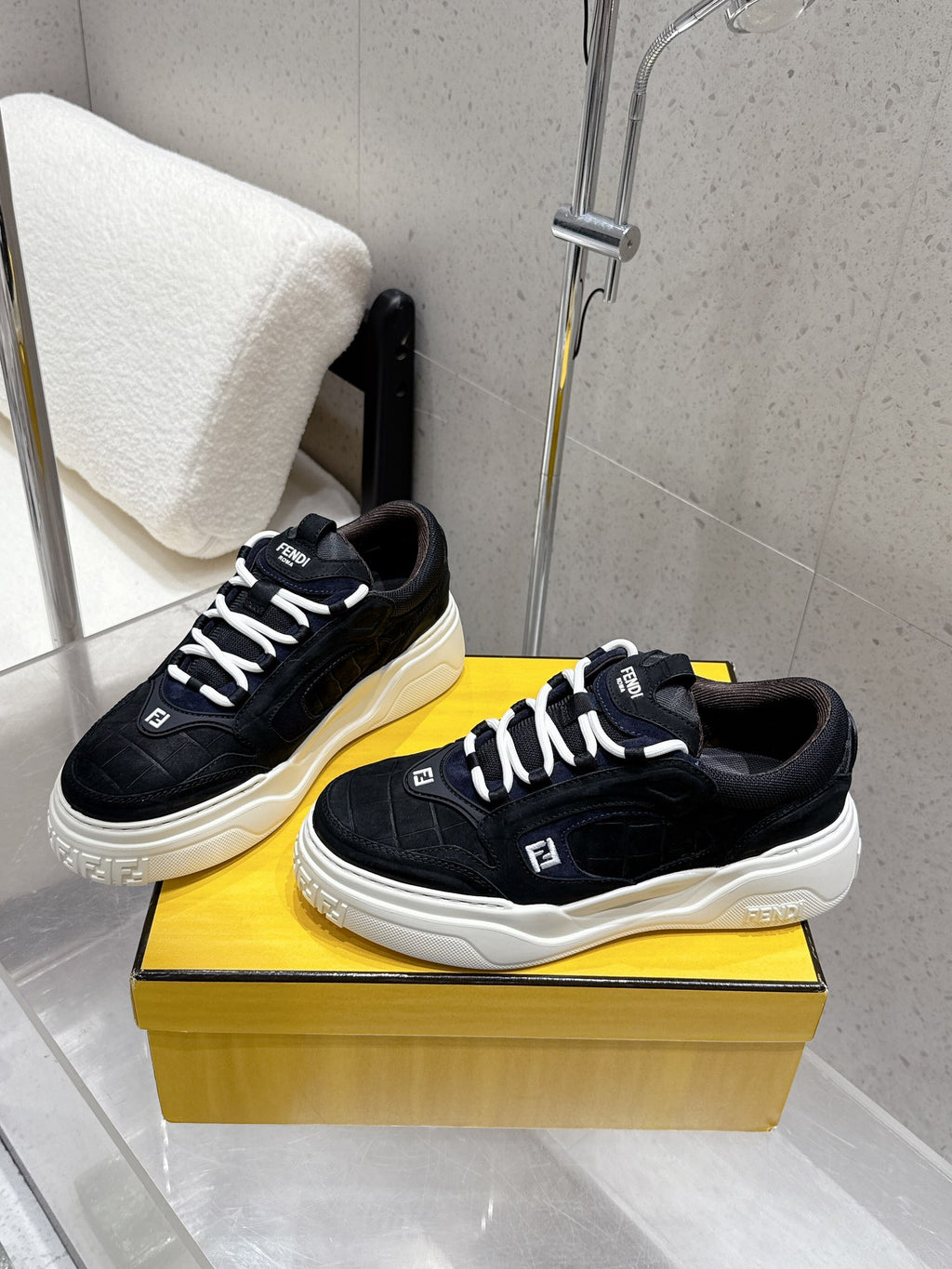 Black Fendi sneakers, white sole and laces, textured side panels and stitching.