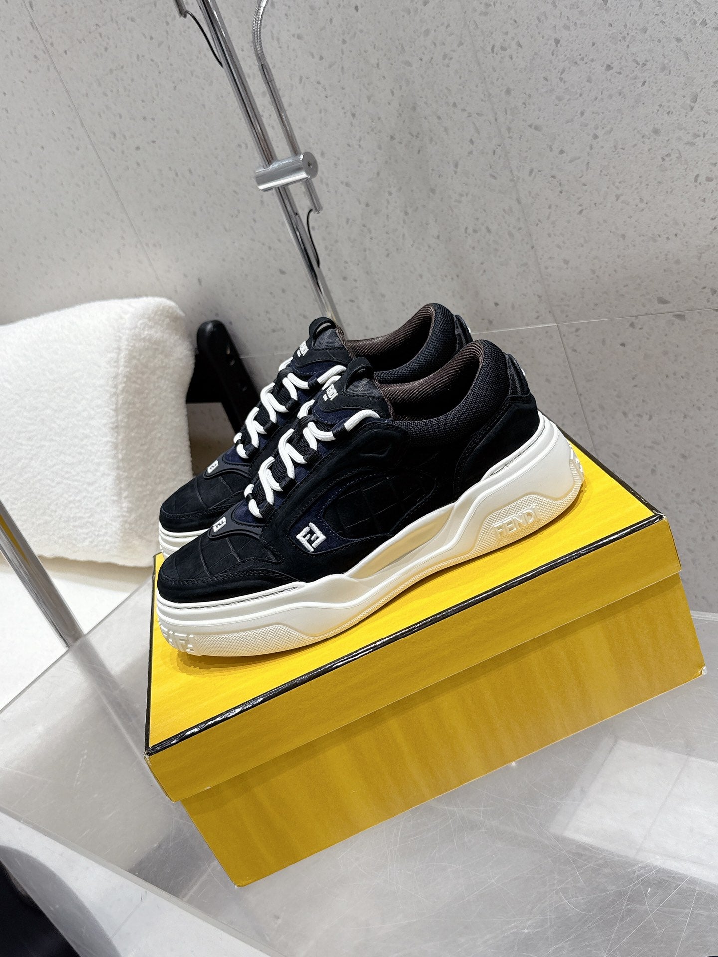 Black Fendi sneakers with chunky white sole, lace-up front and side logo detail.