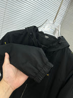 Long jacket held by hand, black hood and sleeve with yellow mini prints