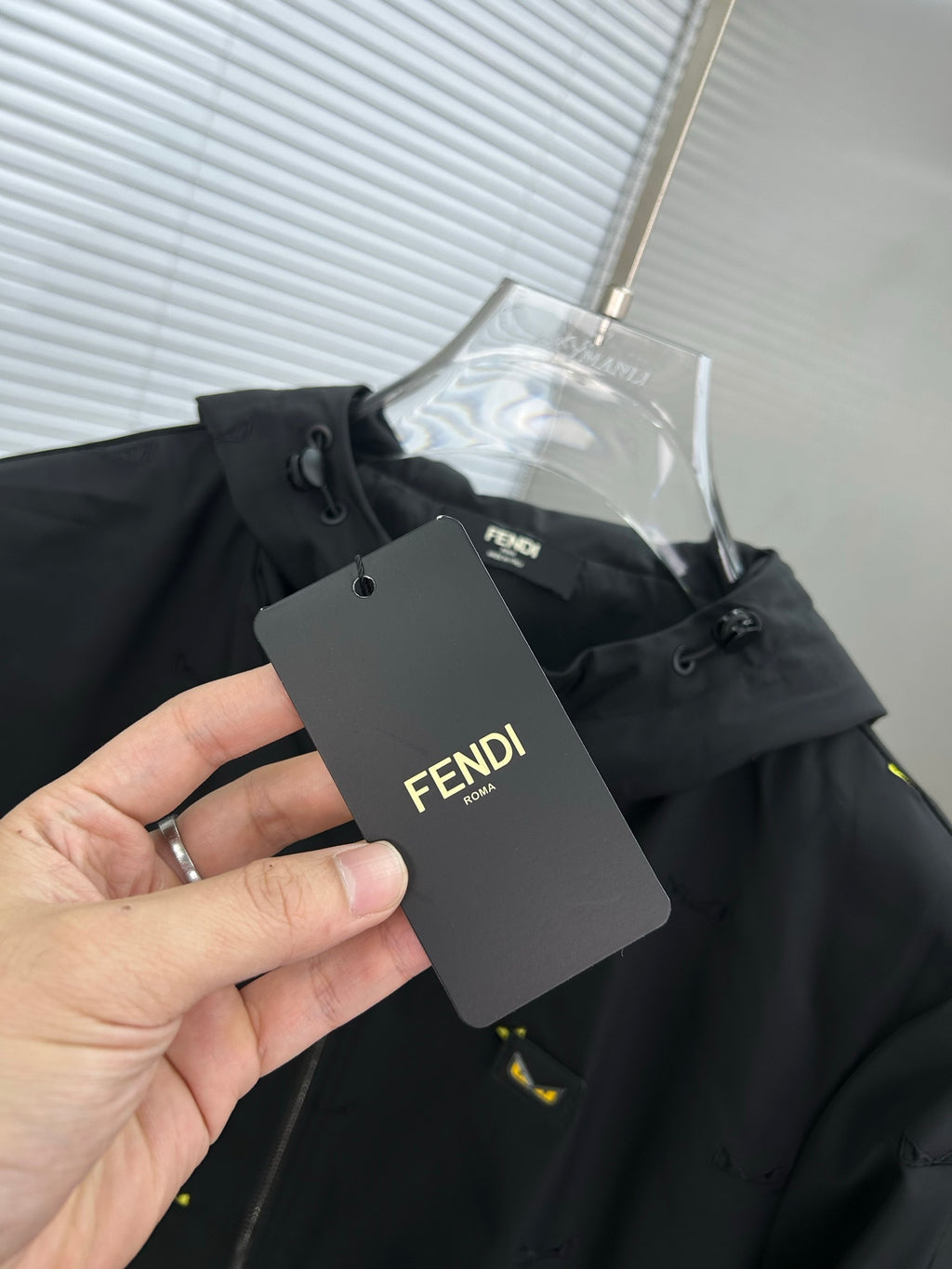 Black hooded jacket with yellow mini prints, hanging Fendi tag