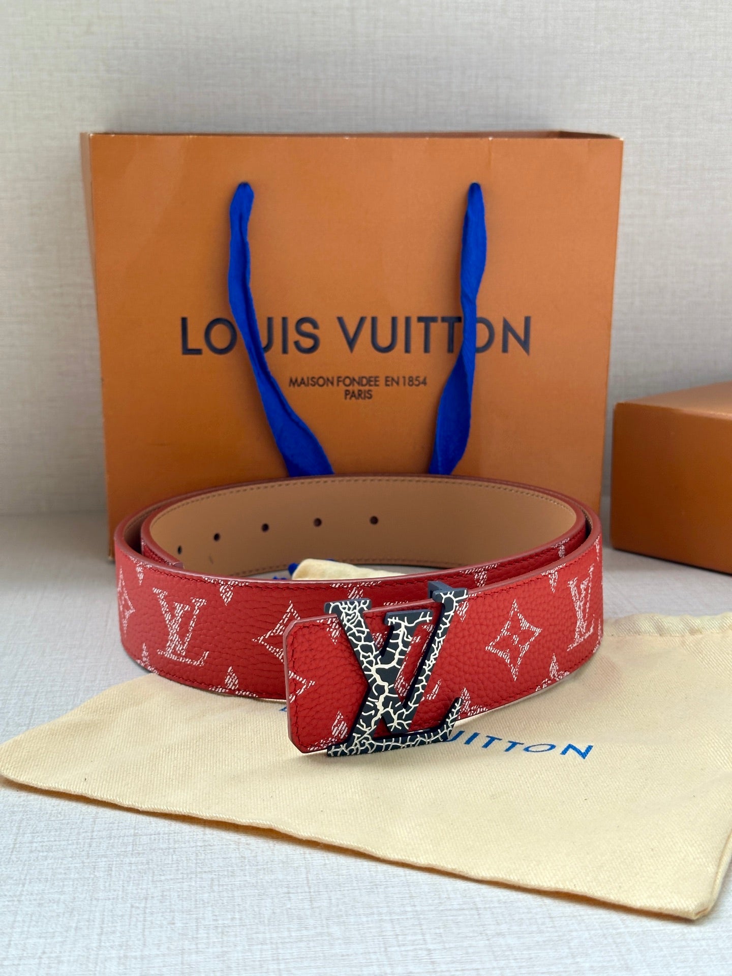 Louis Vuitton belt red monogram with gold LV buckle on tan leather side