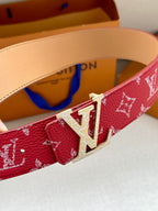 Louis Vuitton belt buckle detail on red monogram strap