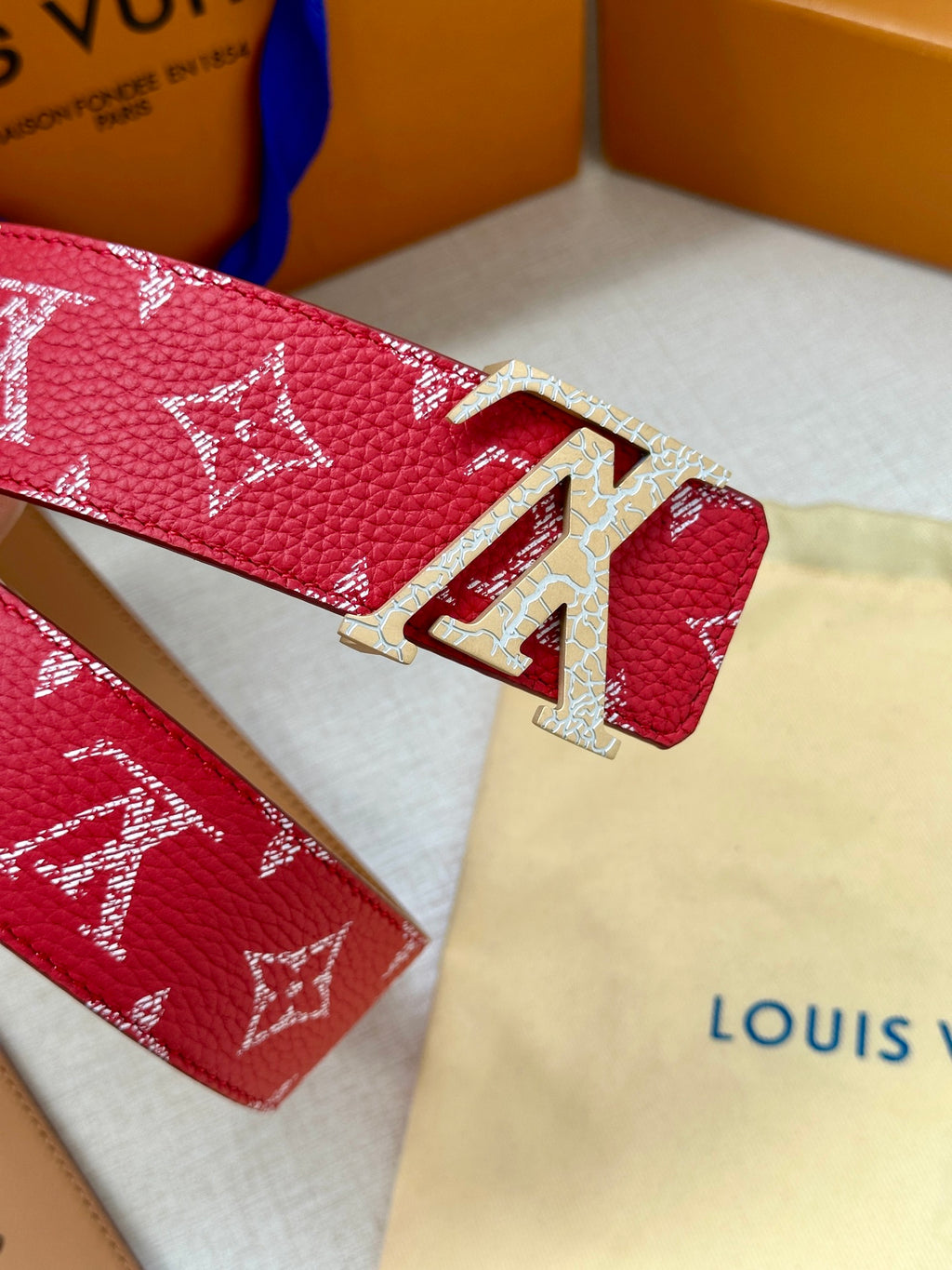 Louis Vuitton belt with red monogram pattern and gold-tone LV clasp