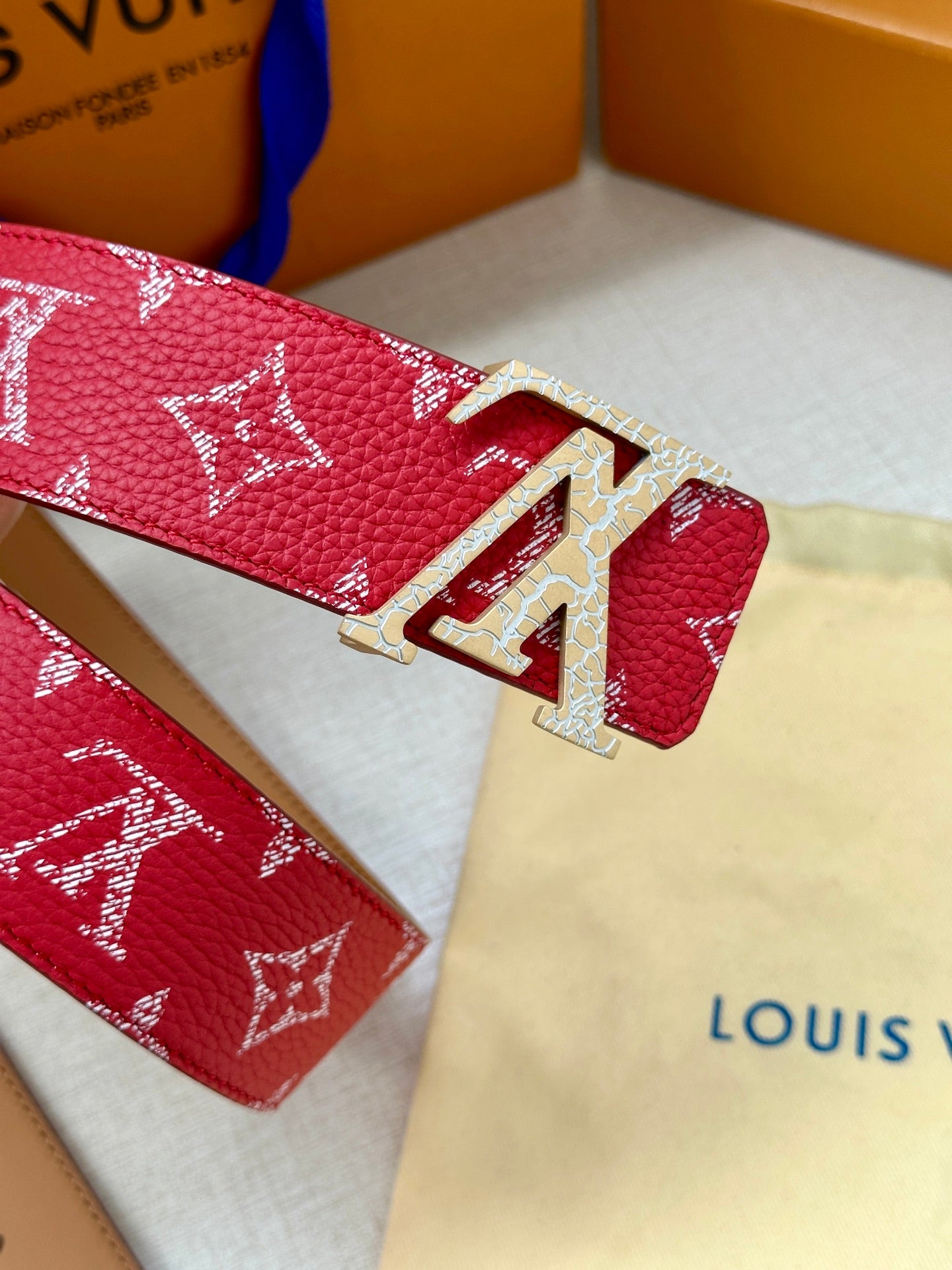 Louis Vuitton belt with red monogram pattern and gold-tone LV clasp