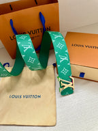 Green Louis Vuitton belt with white monogram and gold-tone LV buckle, holes visible