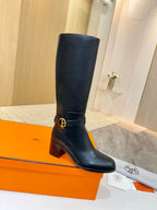 Black leather knee-high boots with gold logo buckle and chunky heel