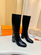 Black leather mid-calf boots with gold logo buckle, side view