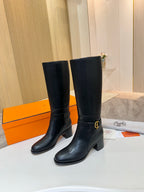 Black leather mid-calf boots with gold logo buckle and stacked block heel