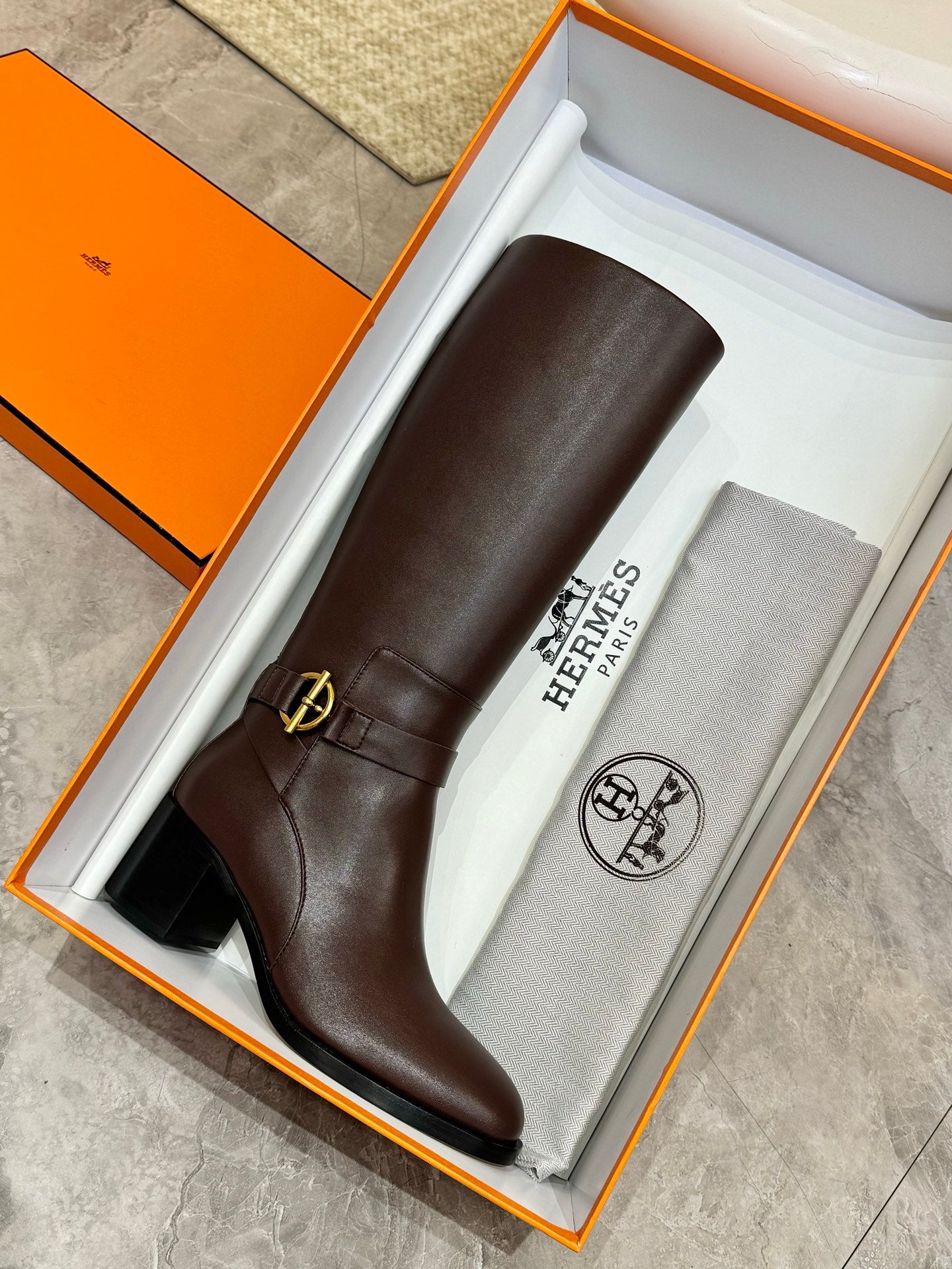 Women's dark brown tall leather boots in box with gold-tone side buckle strap