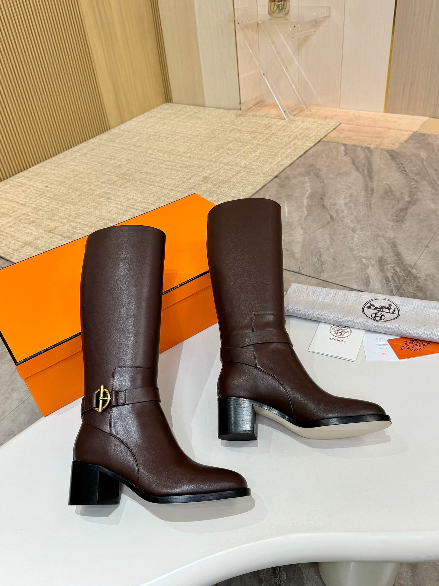 Pair of women's dark brown tall leather boots with gold-tone side buckle