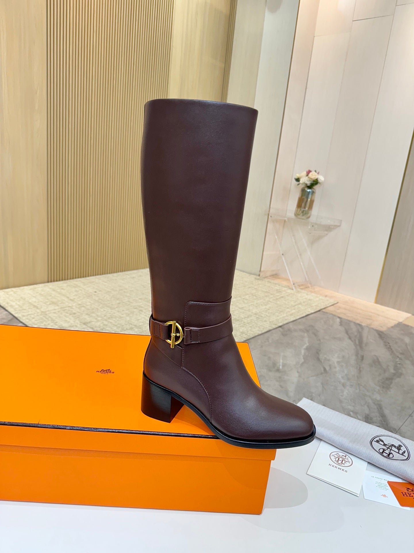 Women's dark brown tall leather boots with gold-tone buckle at side strap