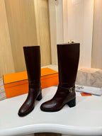 Women's dark brown tall leather boots, front view with gold-tone buckle strap