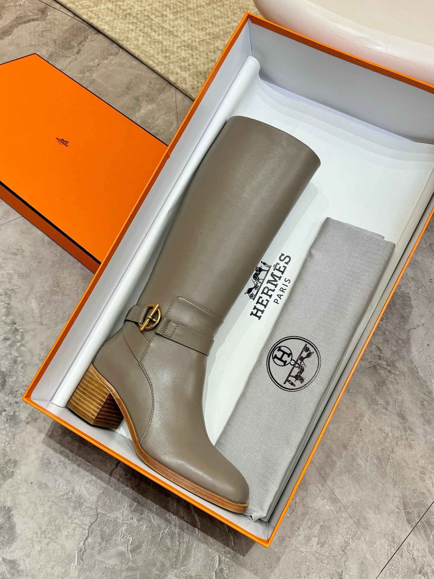 Women’s knee-high gray leather boots with ankle buckle and short stacked block heel