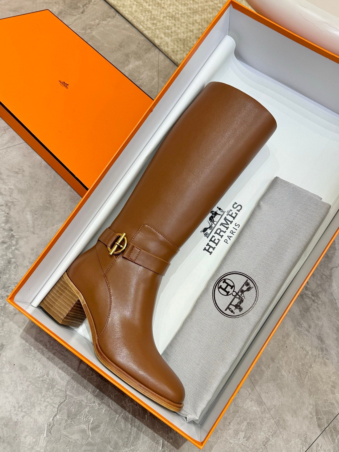Hermes womens brown knee-high leather boot on box, stacked heel and ankle buckle strap