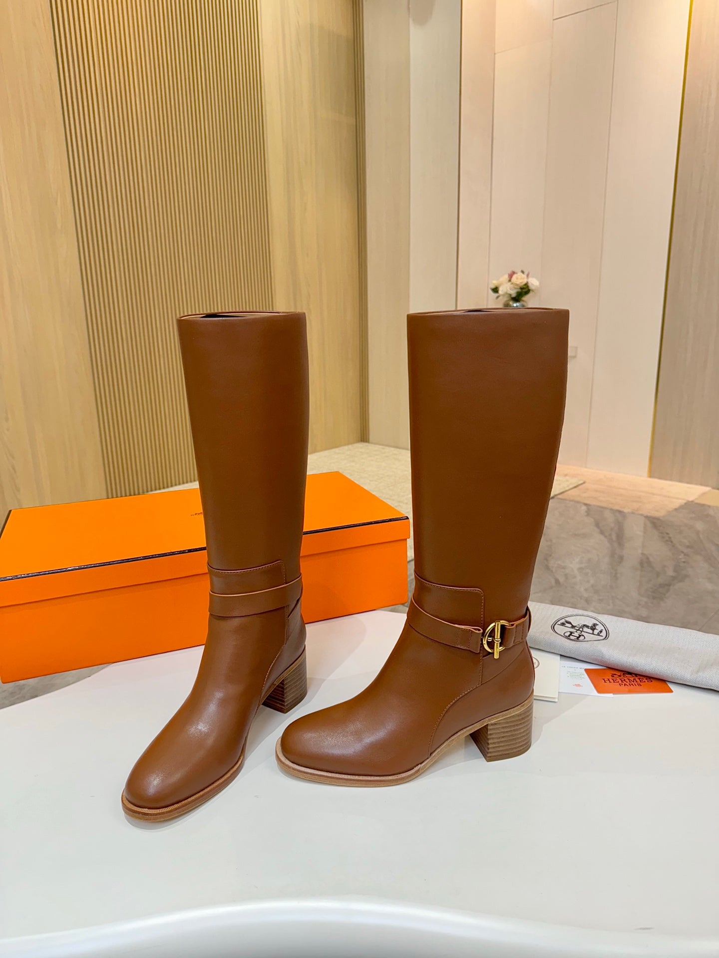 Hermes womens brown knee-high leather boots with stacked heel and ankle buckle detail