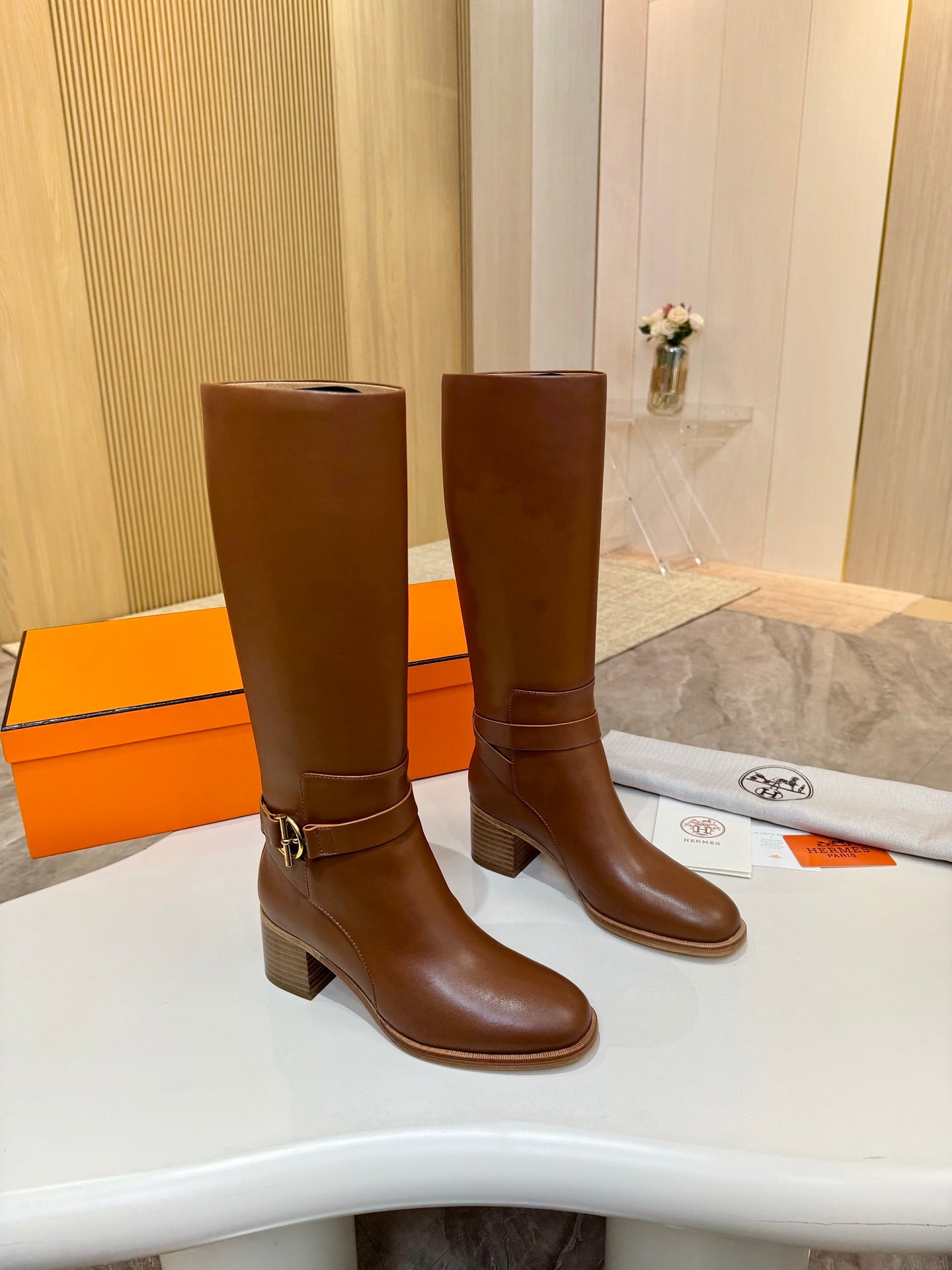 Hermes womens brown knee-high leather boots, side view with gold-tone buckle strap