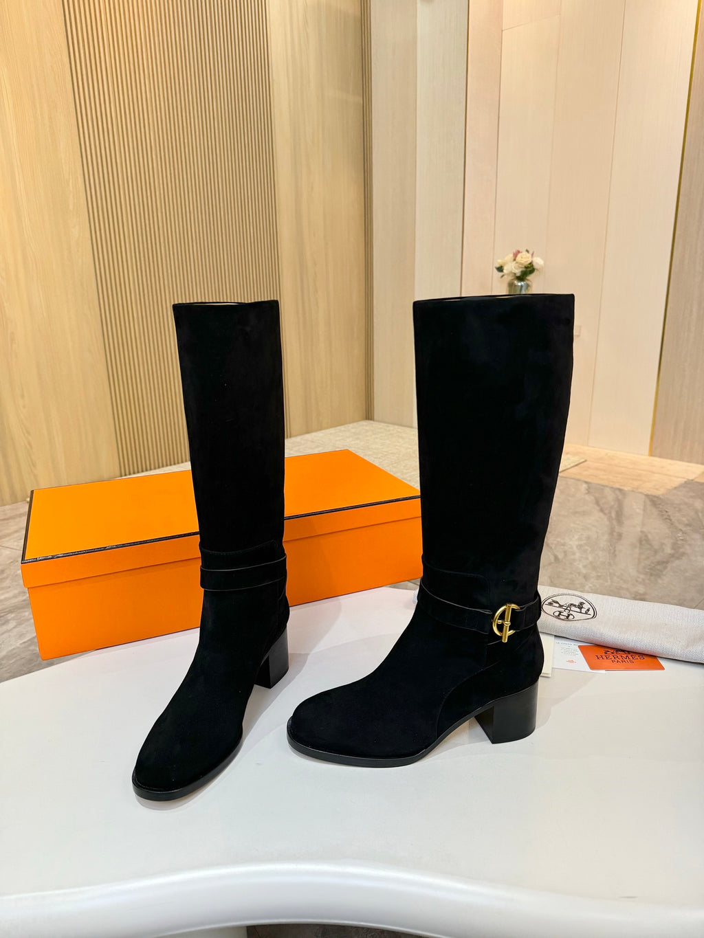 Black suede knee-high boots with gold buckle detail and stacked block heels