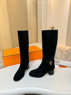 Black suede knee-high boots with gold buckle detail and stacked block heels