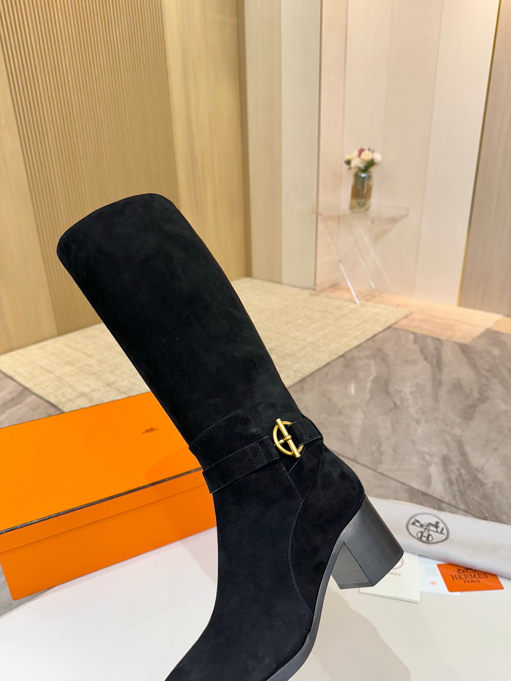 Black suede knee-high boot with gold buckle detail and block heel
