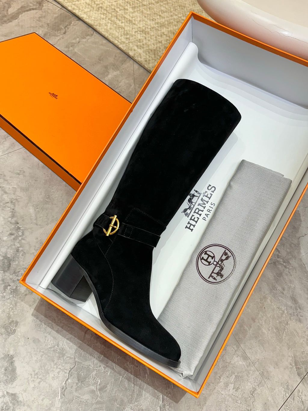 Black suede knee-high boot in orange box with fabric dust bag