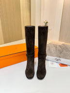 Pair of dark suede knee-high boots with gold-tone buckle strap and heel
