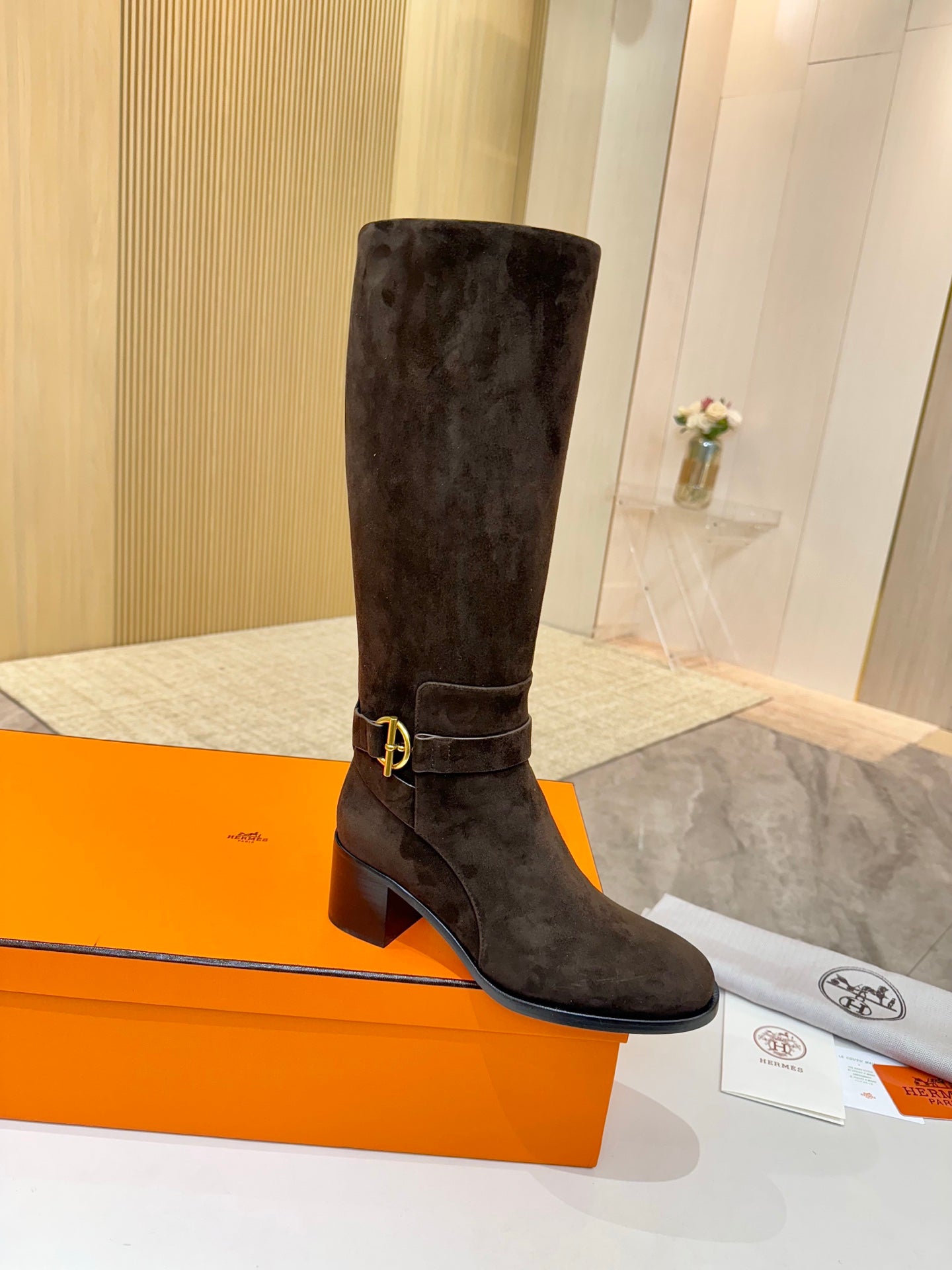 Dark suede knee-high boots with gold-tone buckle strap and block heel