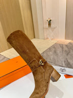 Brown suede mid-calf riding boot with gold-tone ankle buckle and block heel