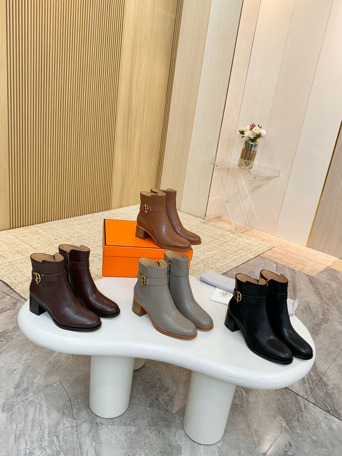 Three pairs of ankle boots with gold buckle: brown, gray, and black