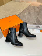 Black leather ankle boots with gold buckle logo and chunky block heel