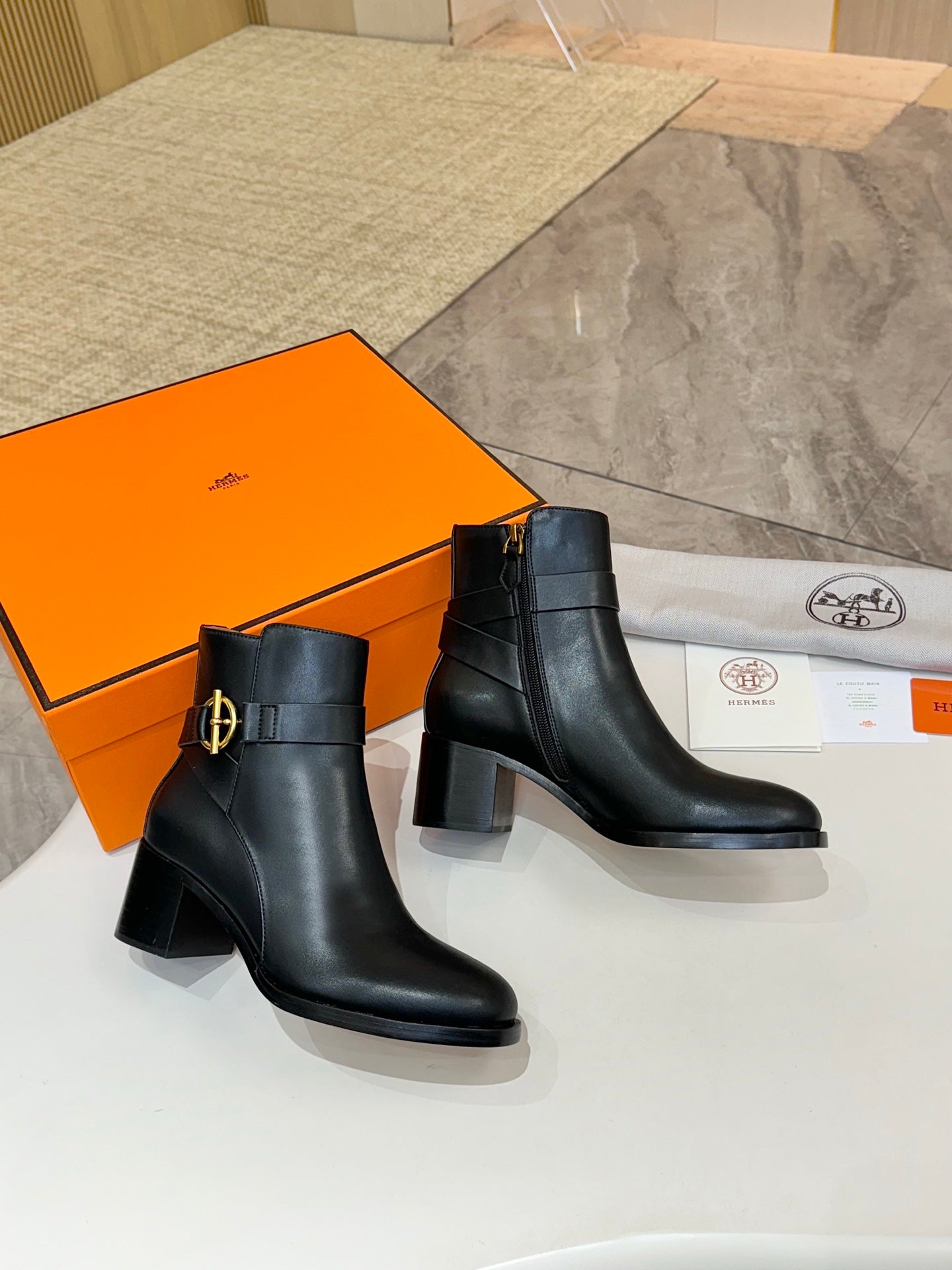 Black leather ankle boots with gold buckle logo and chunky block heel