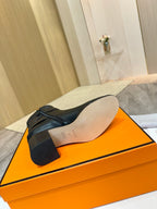 Black leather ankle boot sole view on orange shoebox