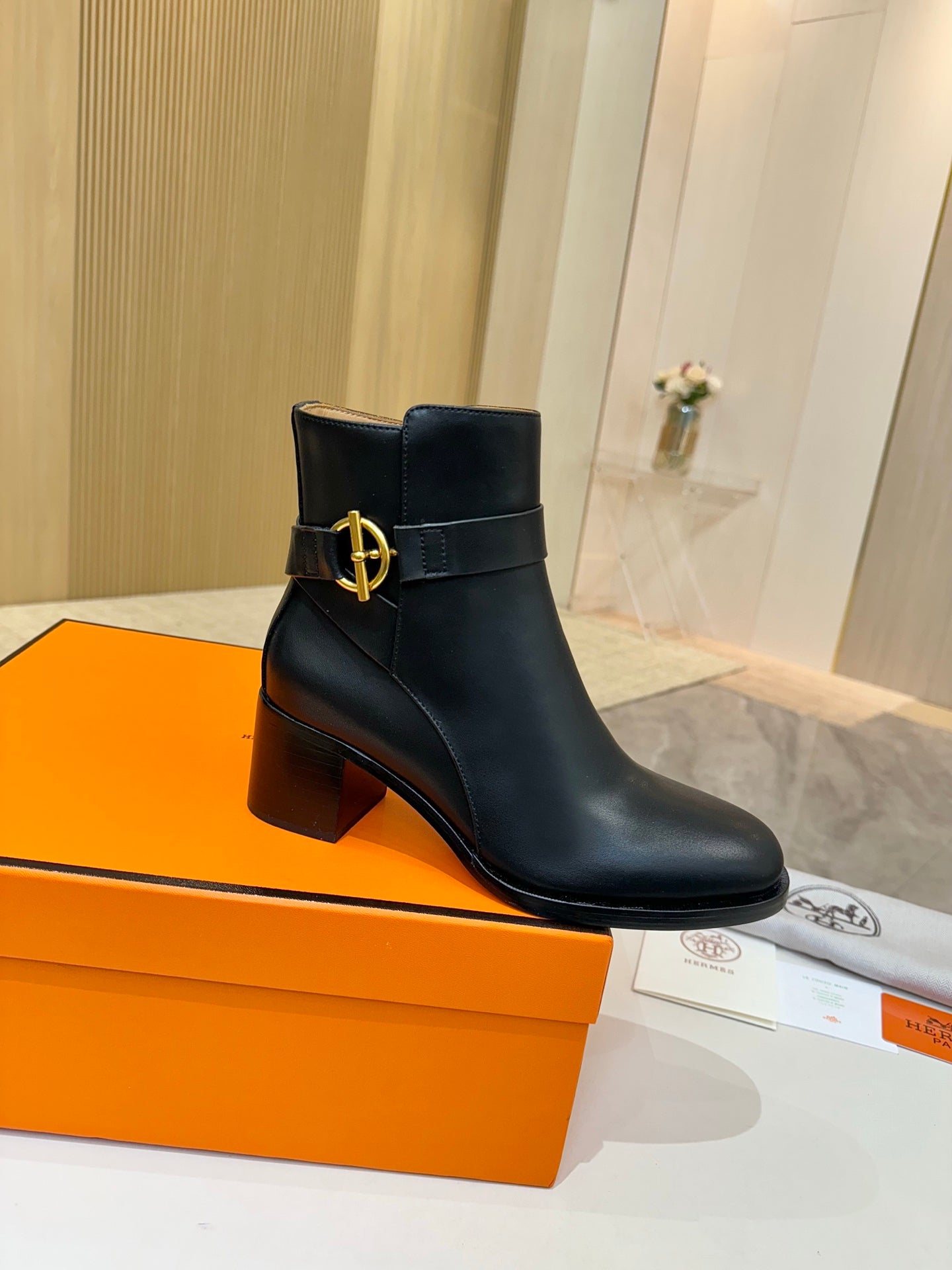 Black leather ankle boots with gold logo detail and stacked block heel