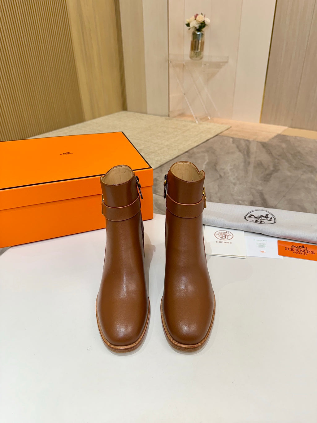 Pair of brown leather ankle boots with block heels and gold buckle accents