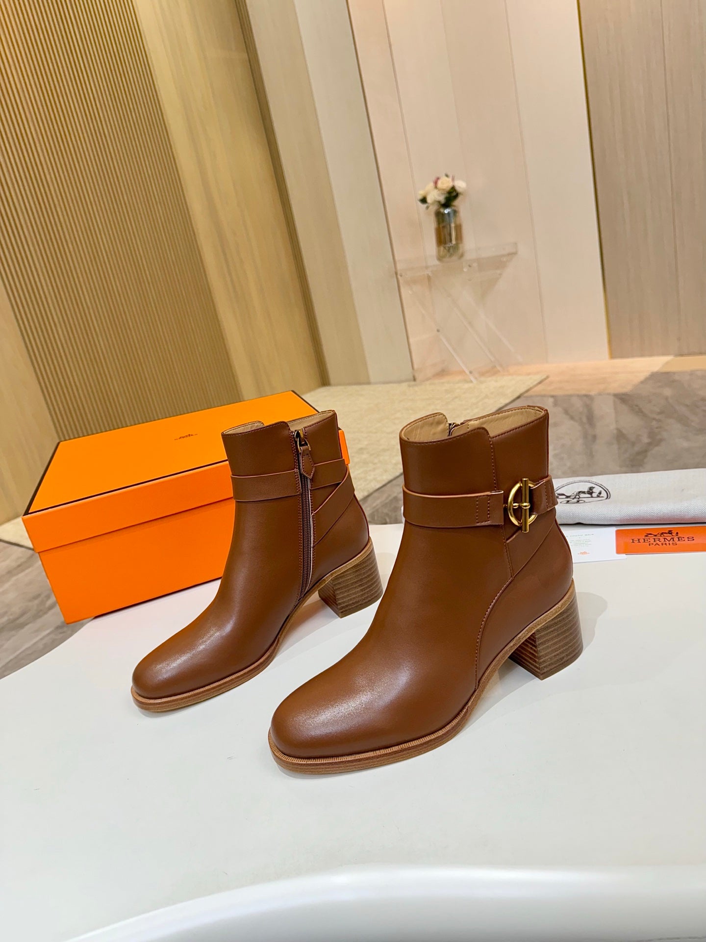 Brown leather ankle boots, side view, with block heel and gold buckle