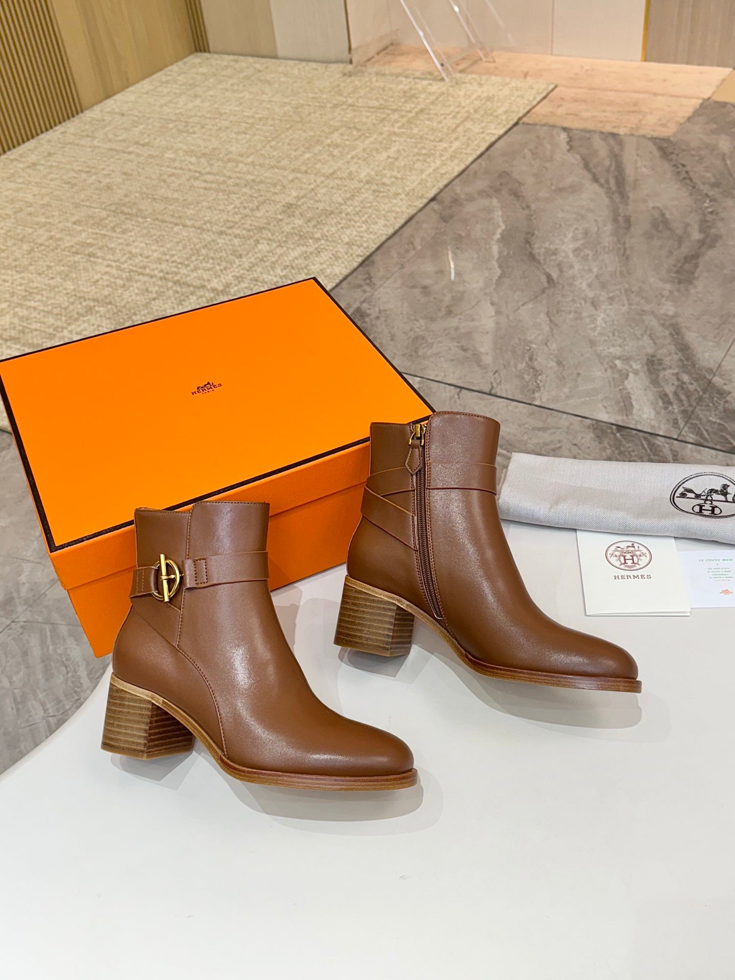 Brown leather ankle boots with block heels and gold buckle strap, side-by-side
