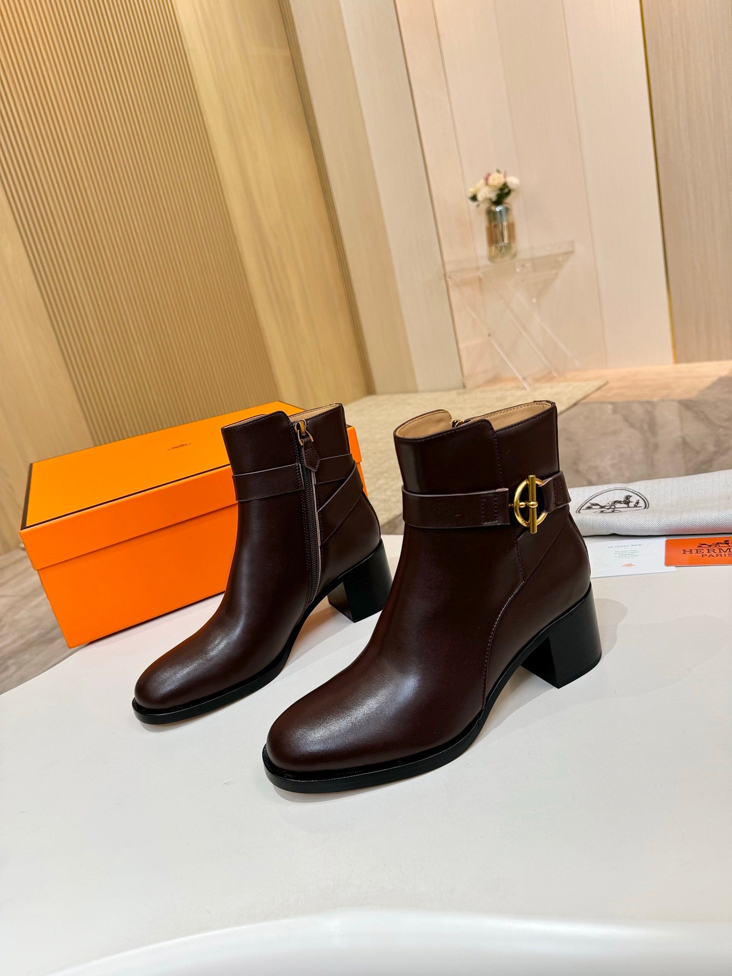 Brown leather heeled ankle boots with gold logo hardware
