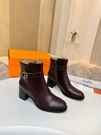Brown leather heeled ankle boots with gold logo buckle, front angle